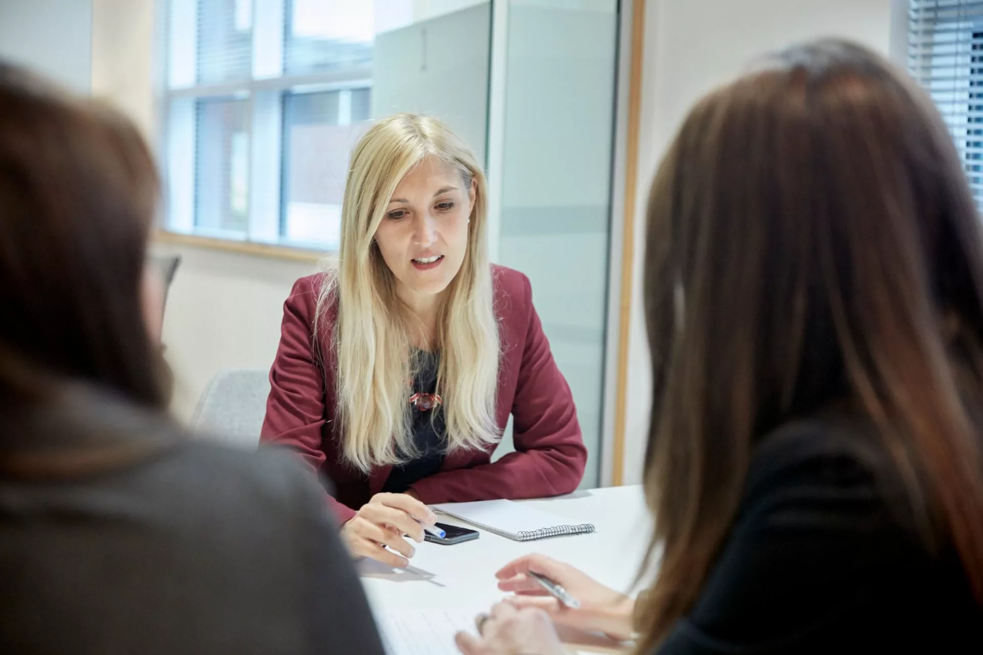 Three people having a meeting in an office looking at documents