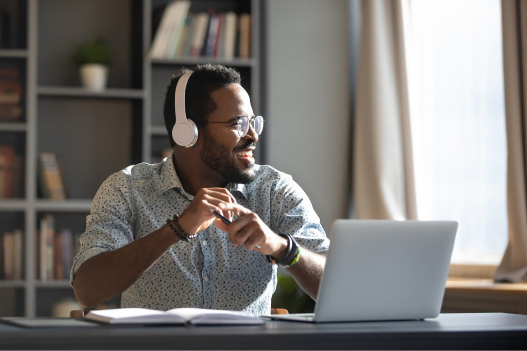 Man working from home at his laptop wearing headphones