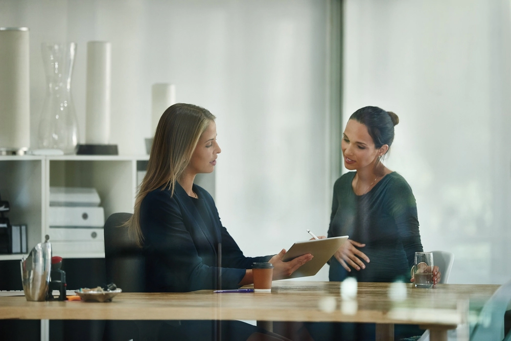 Two business people in discussion over a tablet.